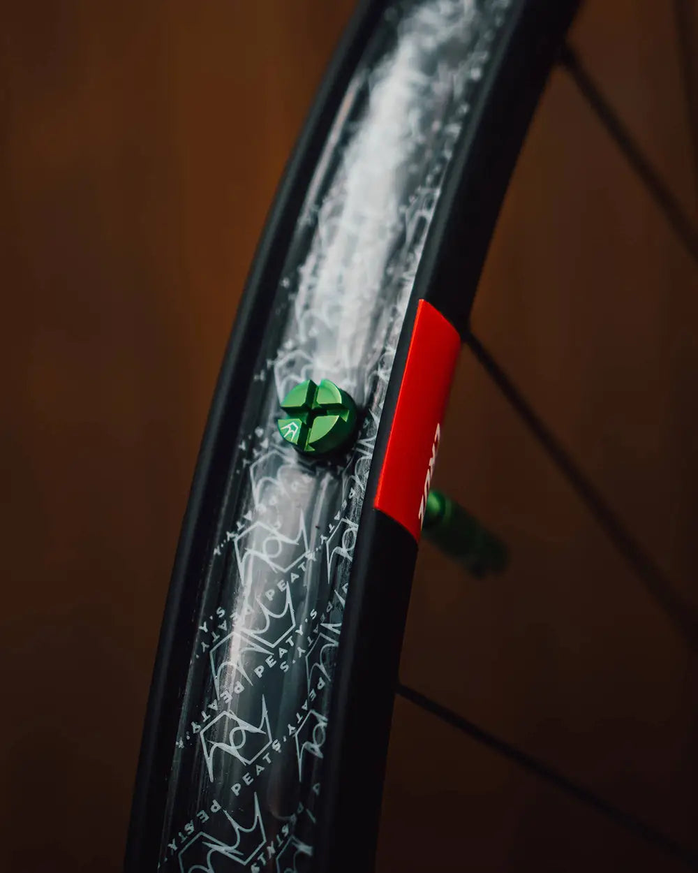 Peaty's Mk2 Tubeless Valves in emerald, on a bike, inside rim shot